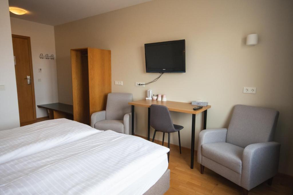 una camera d'albergo con un letto, una scrivania e una TV di Hótel Búrfell a Vík