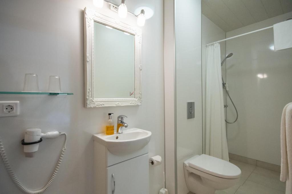 un bagno bianco con un water e un lavandino di Hótel Búrfell a Vík