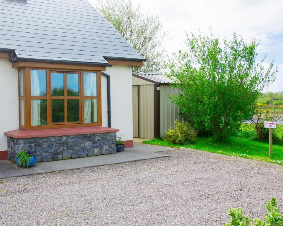a house with a window and a gravel driveway at Charming 1-Bed Apartment in Ardfert Tralee 