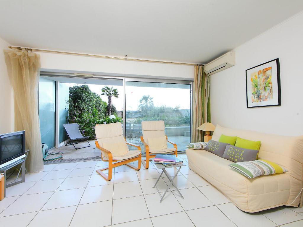 a living room with a couch and chairs and a tv at Apartment Cannes Bay-2 by Interhome in Cannes