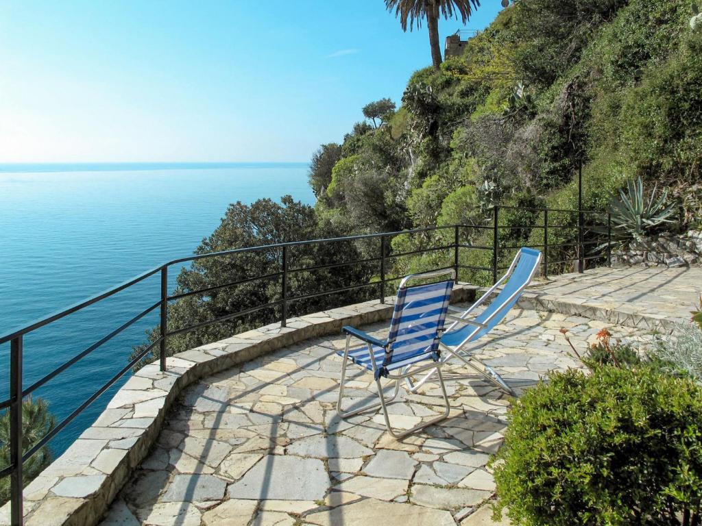 ヴェンティミリアにあるApartment Gli Smeraldi by Interhomeの海の横の階段に座る青い椅子