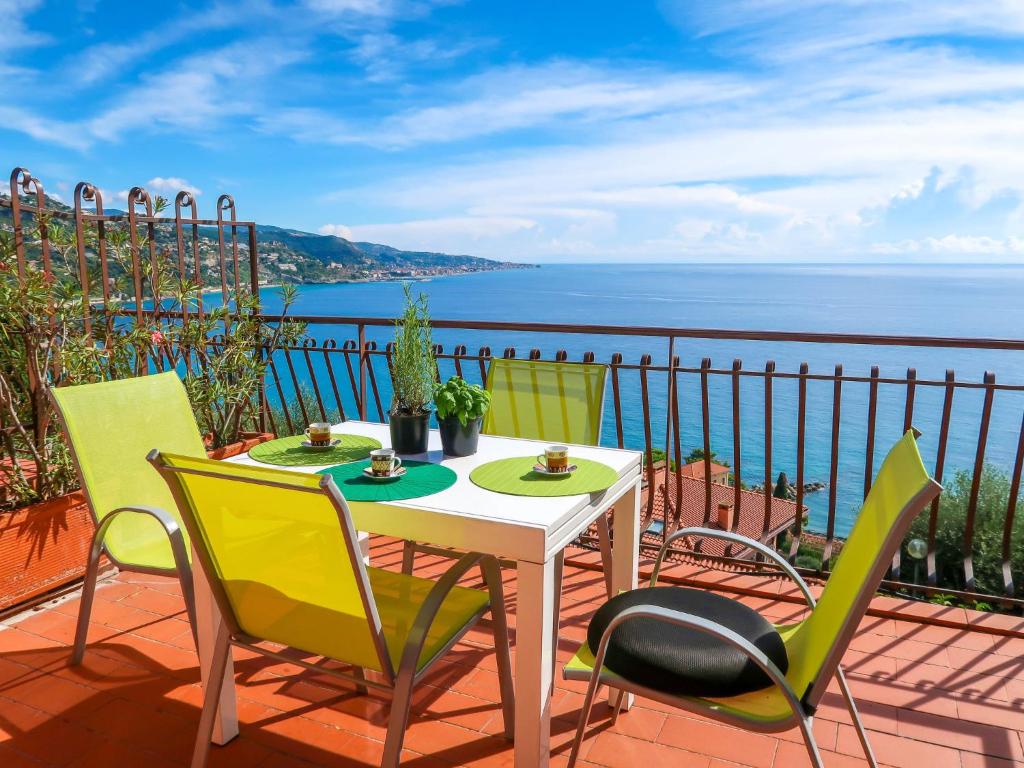 einen Tisch und Stühle auf einer Terrasse mit Meerblick in der Unterkunft Apartment Paradise View by Interhome in Mortola Inferiore