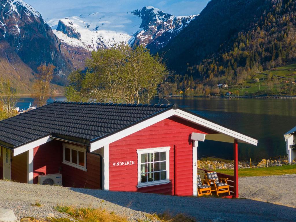 um barracão vermelho com uma montanha ao fundo em Holiday Home Vindreken - FJS019 by Interhome em Balestrand