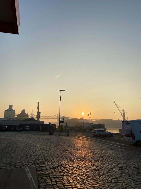 einen Sonnenuntergang über einer Kopfsteinpflasterstraße in einer Stadt in der Unterkunft Atelier Achtung Ausblick! in Rendsburg