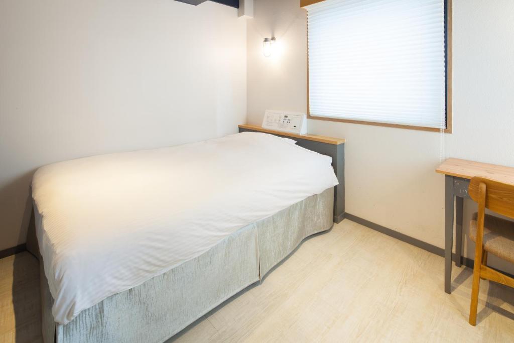 Tempat tidur dalam kamar di Shinjuku City Hotel N.U.T.S Tokyo