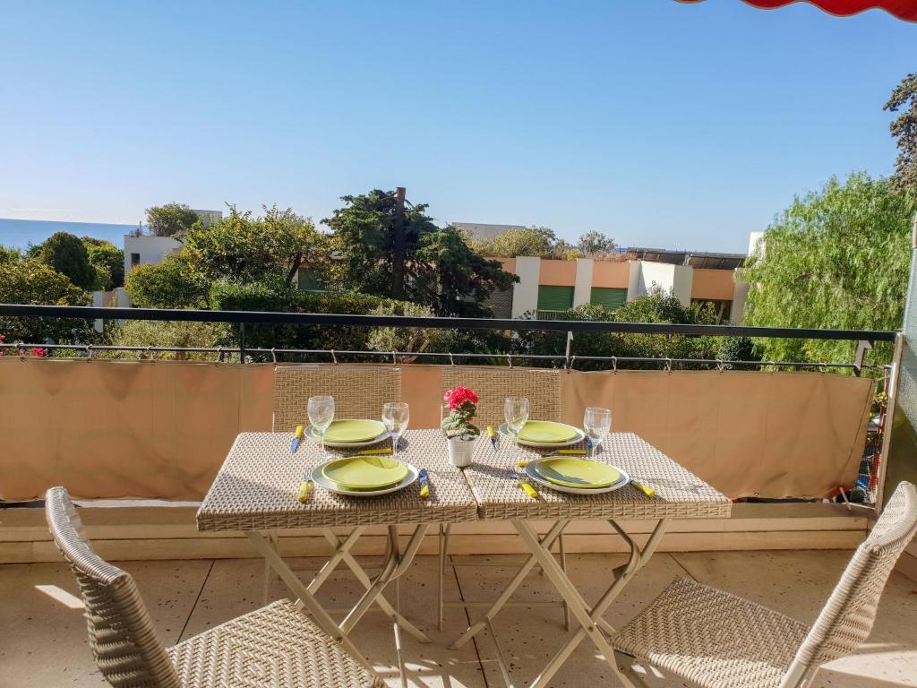 a table with plates and glasses on a balcony at Apartment Le Roc by Interhome in Cannes
