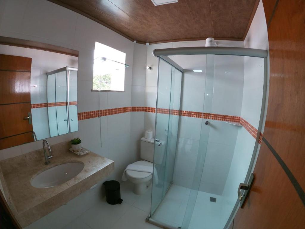 a bathroom with a glass shower and a toilet at Hotel Morro De São Paulo in Morro de São Paulo