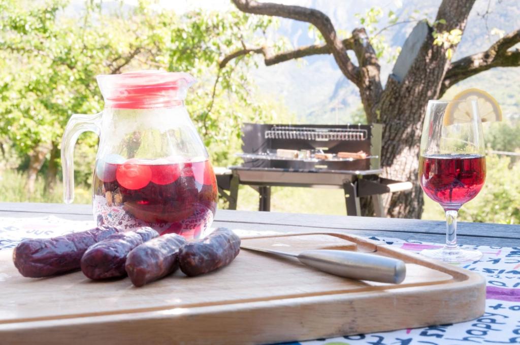 un frasco de frutas y hortalizas en una mesa con una copa de vino en La Crotta Gignod - CIR VDA GIGNOD 002, en Aosta