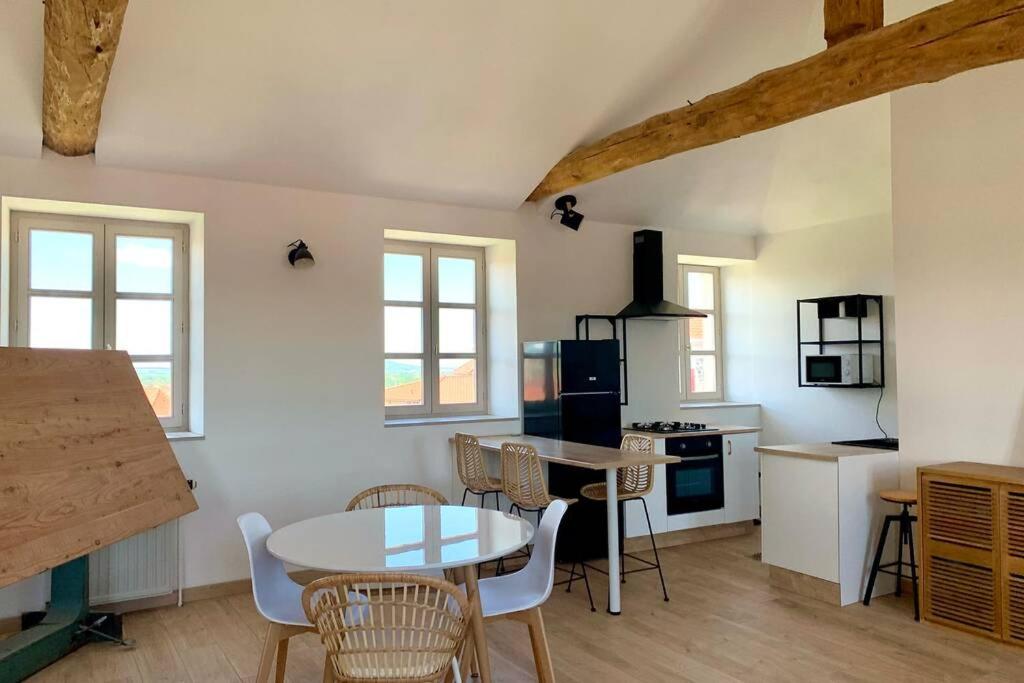 a kitchen with a table and chairs in a room at La providence, surplombant la ville in Montbrison