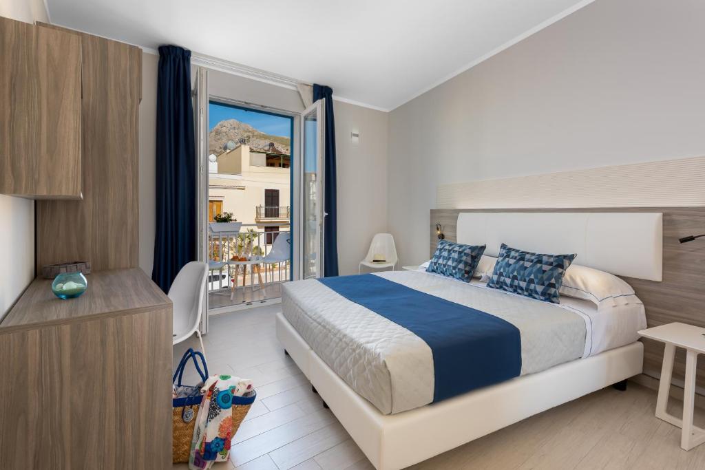 a bedroom with a bed and a large window at Scrusciu du mari in San Vito lo Capo