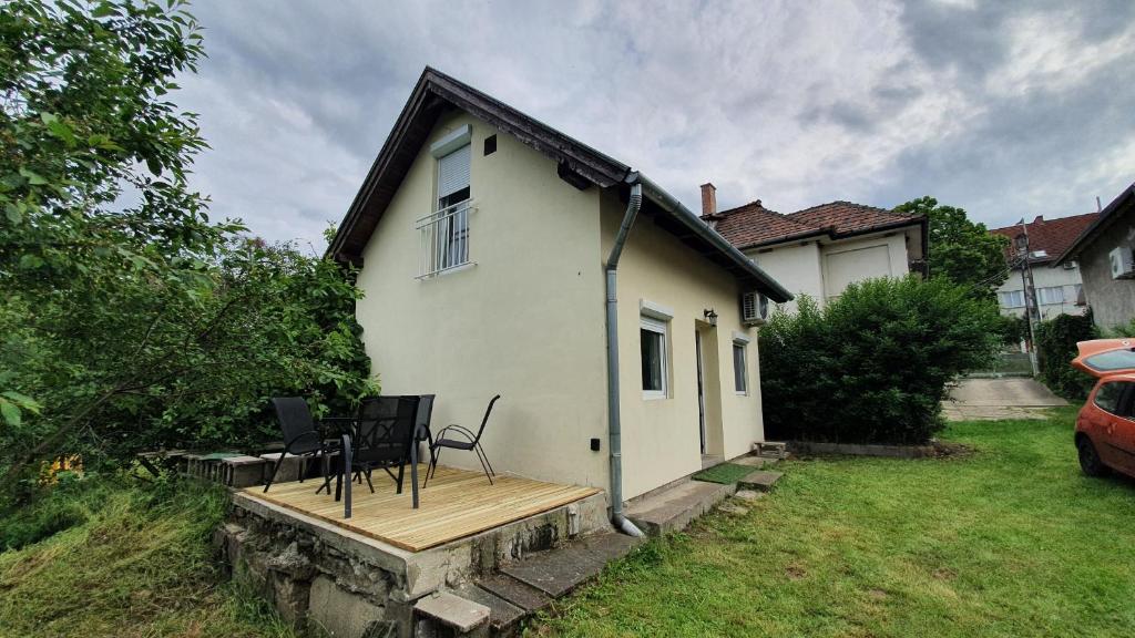 una casa con una terraza de madera con sillas en Littlepanther Balaton, en Balatonföldvár