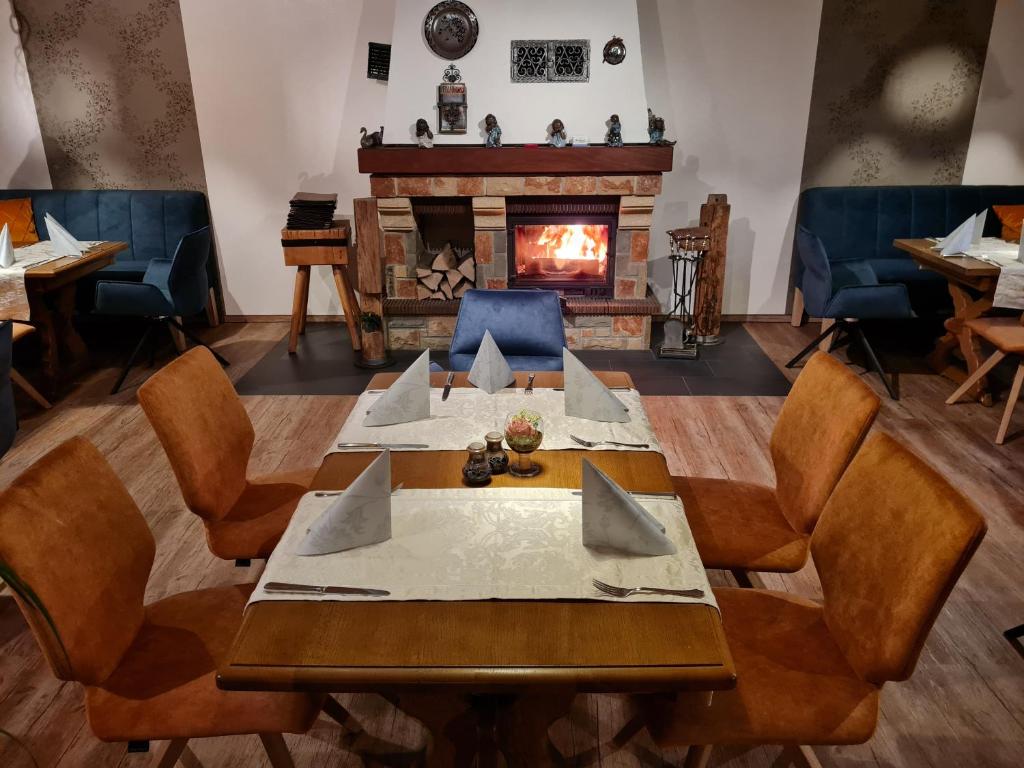 a dining room with a table and a fireplace at Zur Kringelwies in Masburg
