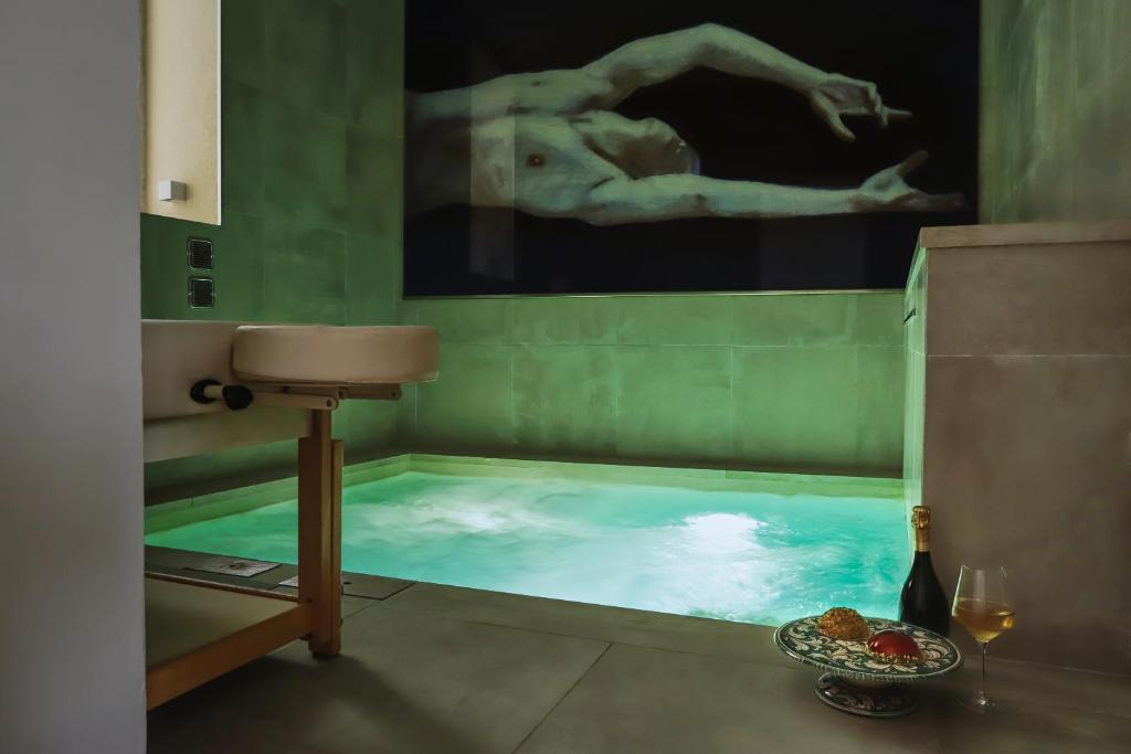 ein Badezimmer mit einem Pool mit einem Gemälde in der Unterkunft AuriSPA 143 CON PISCINA NOTO CENTRO in Noto
