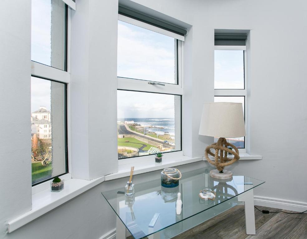 a glass table in a room with windows at Apt3, No 2 Antrim Gardens, Portrush with Seaview in Portrush