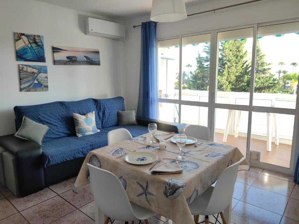 uma sala de estar com uma mesa e um sofá azul em Apacos muy cerca playa Entrada Autónoma em Algarrobo
