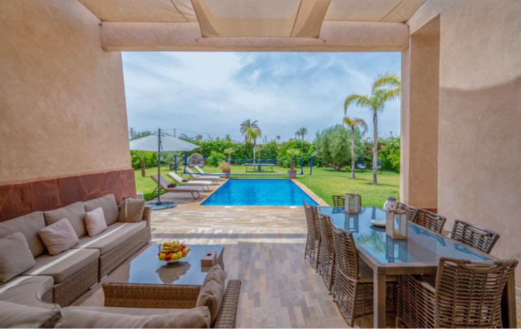 a patio with a table and chairs and a pool at Villa Stean in Marrakech