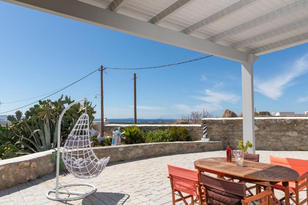 een patio met een houten tafel en stoelen bij The Stone House Naxos in Glinado Naxos