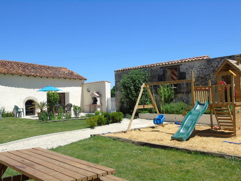 - une aire de jeux avec toboggan et banc dans la cour dans l'établissement Limerac Cottage, à Salles-Lavalette