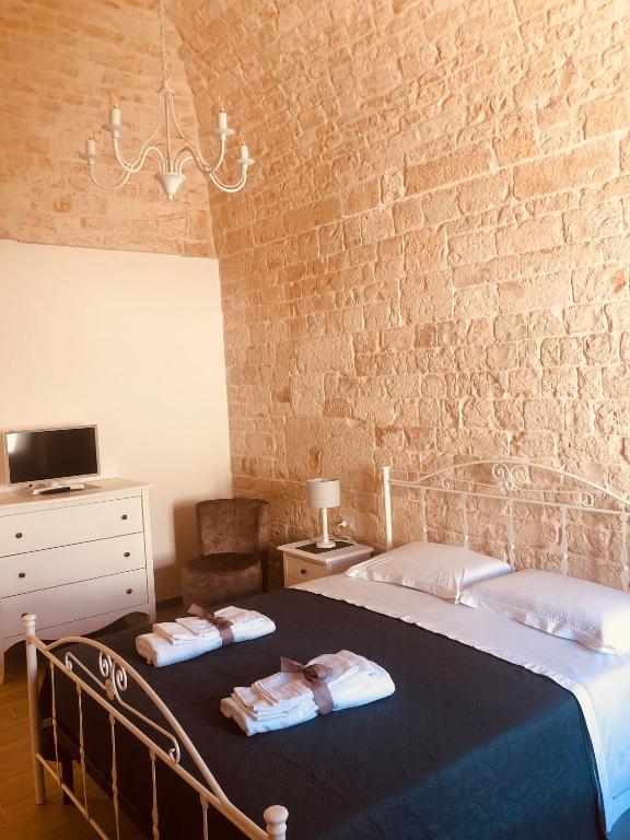 sypialnia z 2 łóżkami i ceglaną ścianą w obiekcie Nido di pietra-dimora in centro w Alberobello
