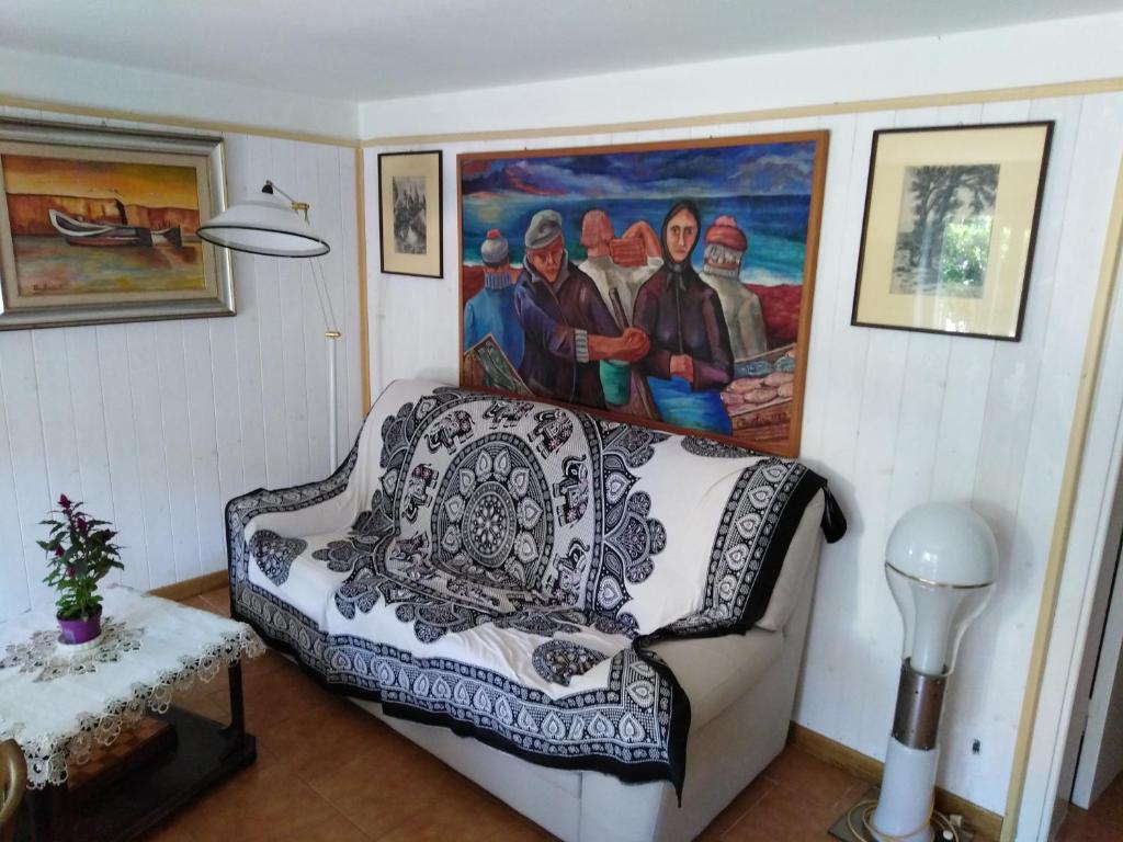 un soggiorno con divano e un dipinto sul muro di casa di Enzo:relax a 2 passi dal mare a Camaiore