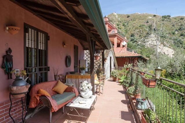 um alpendre de uma casa com um sofá e uma mesa em Carly & Dane Vacation House em Taormina