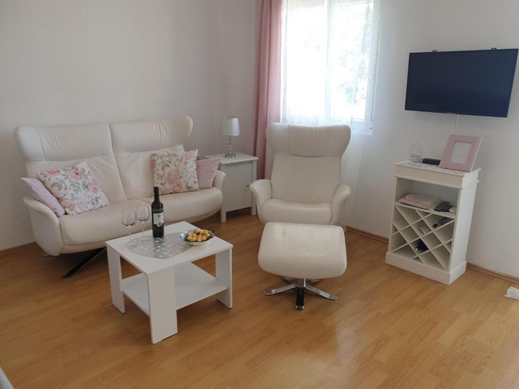 uma sala de estar com um sofá, uma cadeira e uma mesa em Apartments Mare em Banjol