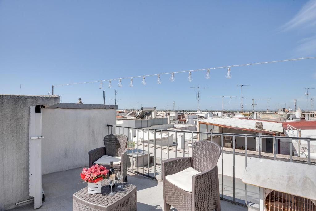 balkon z 2 krzesłami i stołem z kwiatami w obiekcie Casa Alessandra Terrace Flat in Conversano w mieście Conversano