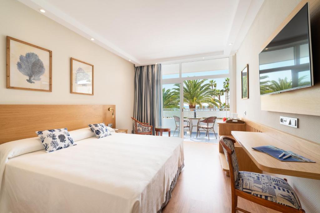 Cette chambre comprend un lit, un bureau et une fenêtre. dans l'établissement VIK Hotel San Antonio, à Puerto del Carmen