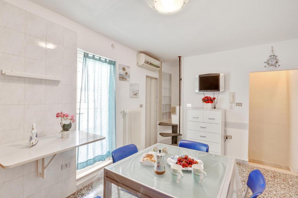 kuchnia ze stołem i niebieskimi krzesłami w pokoju w obiekcie Casa Alessandra Terrace Flat in Conversano w mieście Conversano