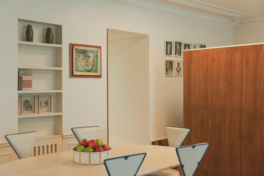 a dining room with a table and a bowl of fruit at Pied A Terre - Palestro in Paris