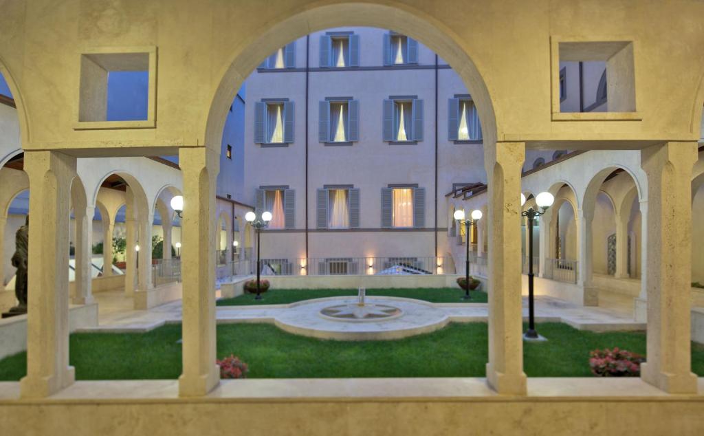 a building with arches and a courtyard with a fountain at Domus Australia in Rome