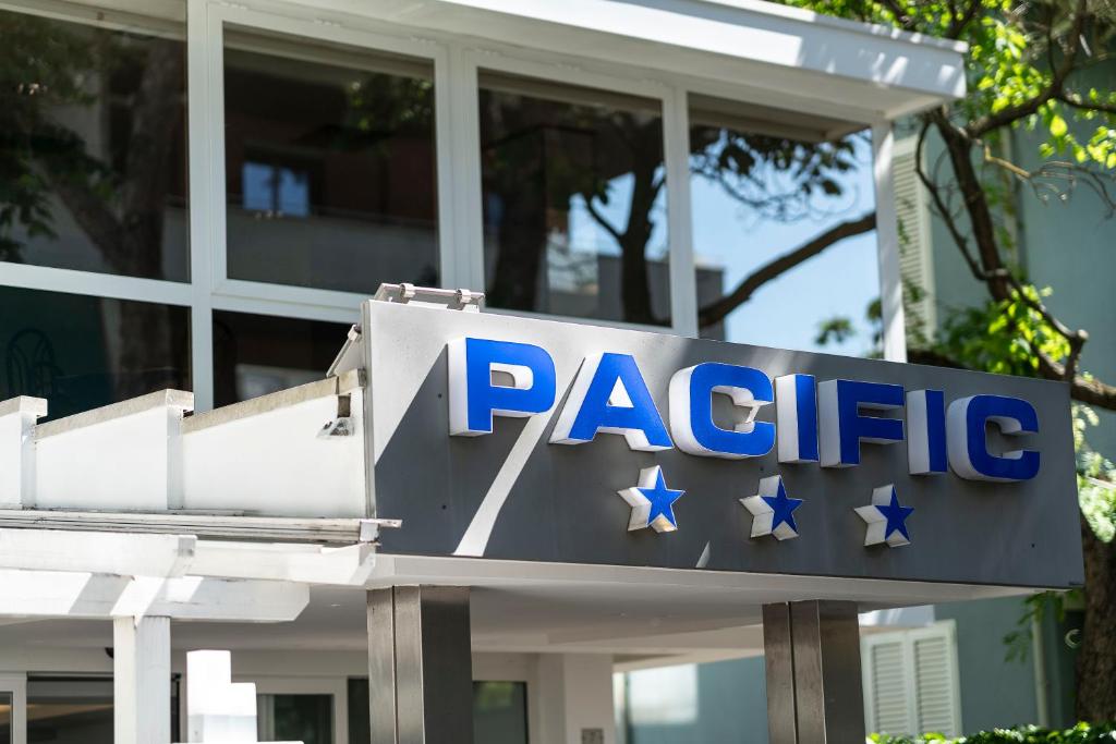 un panneau devant un bâtiment avec des étoiles dessus dans l'établissement Hotel Pacific, à Riccione