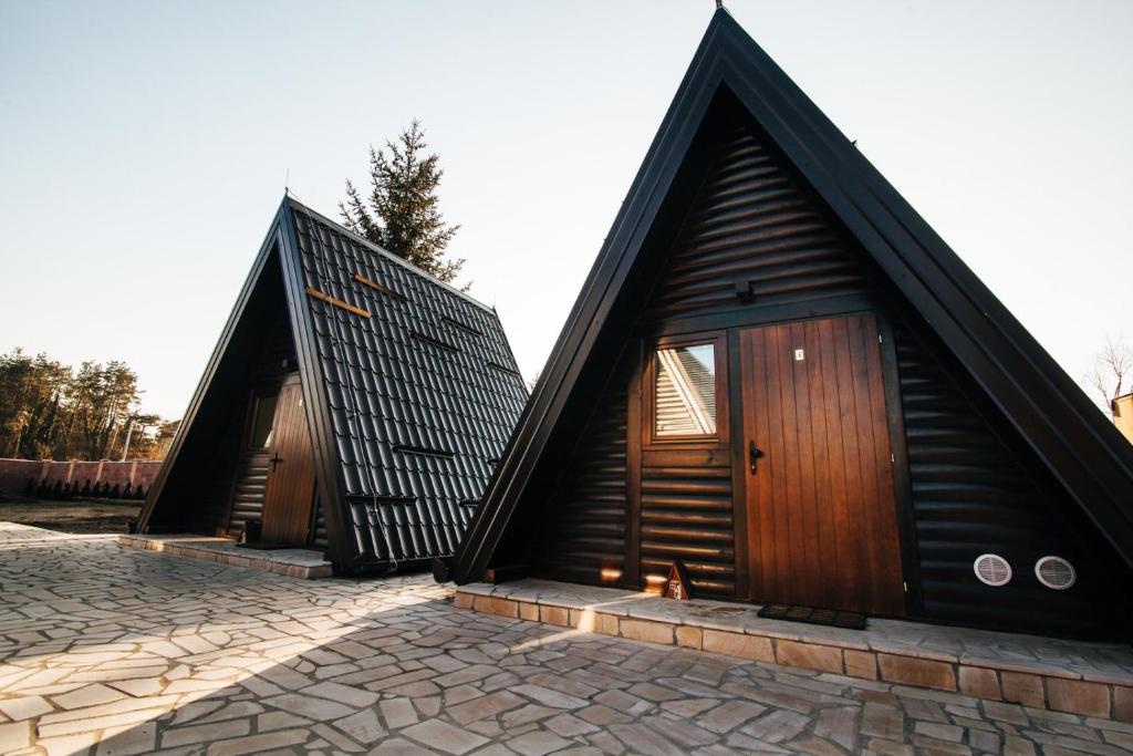 a small house with a pointed roof on a stone floor at Ribarski konaci in Doboj