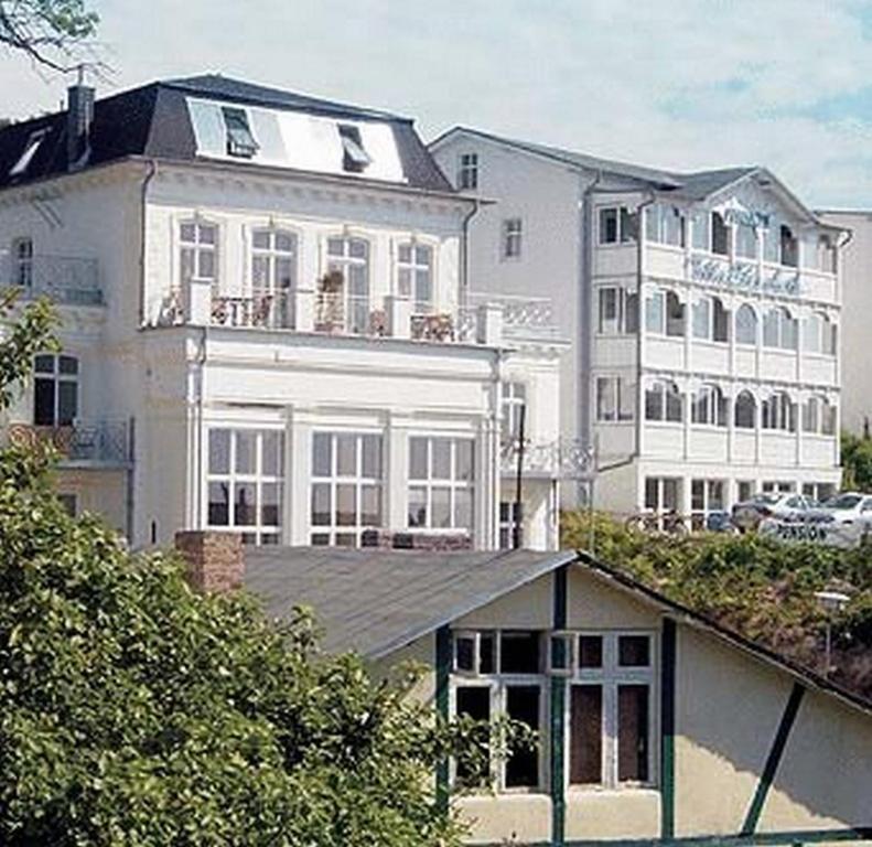 ein großes weißes Gebäude mit Balkon darüber in der Unterkunft Pension Villa Elisabeth in Sassnitz