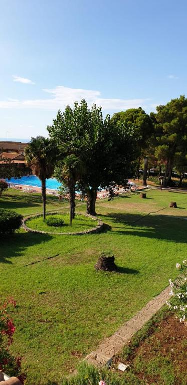 a park with trees and a body of water at Delia's house in Drapia