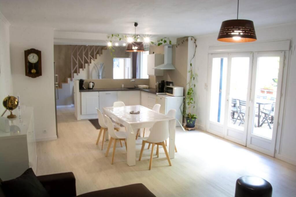 une cuisine et une salle à manger avec une table et des chaises blanches dans l'établissement La maison de Papé, à Arles