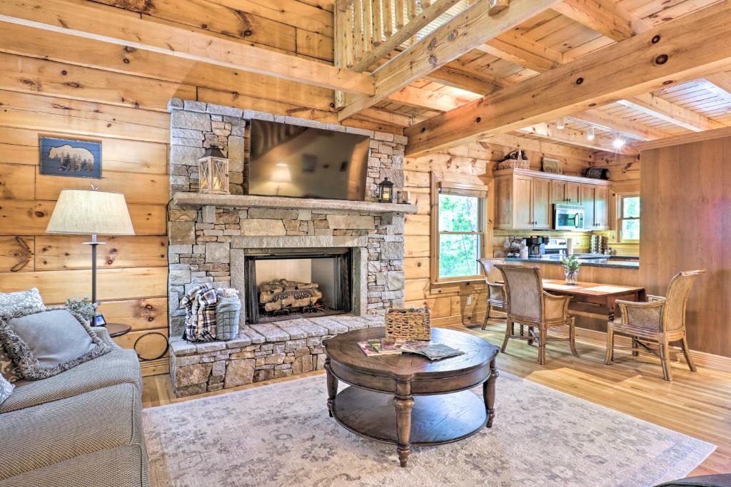 a living room with a stone fireplace and a table at Cozy Retreat with Deck and Sapphire Resort Access! in Sapphire