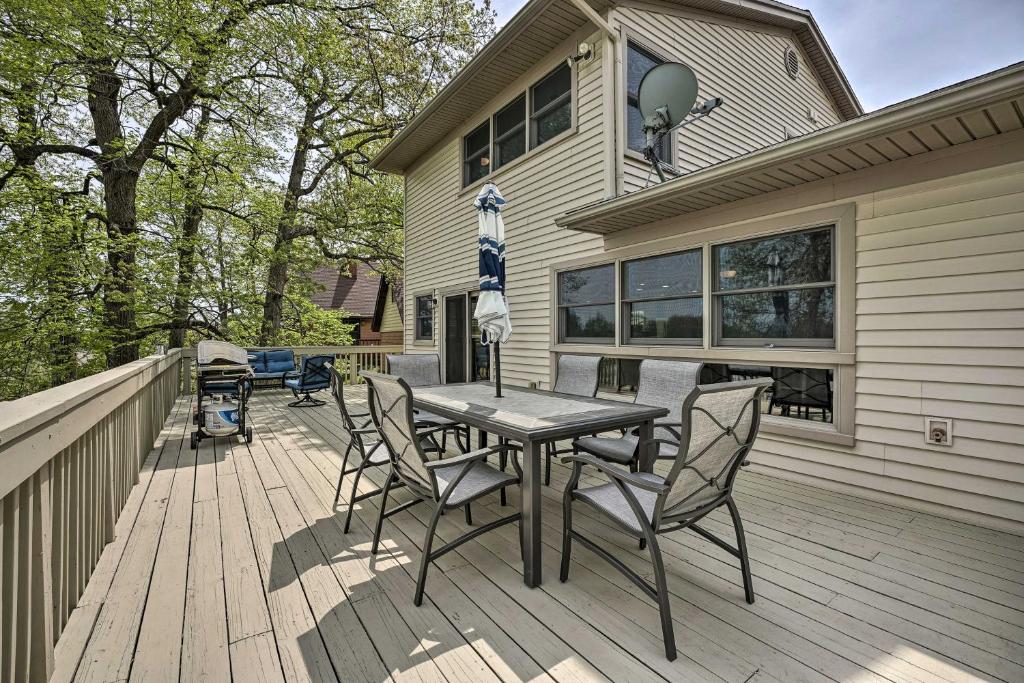 a wooden deck with a table and chairs on a house at Pet-Friendly Grass Lake Retreat with Game Room! in Grass Lake