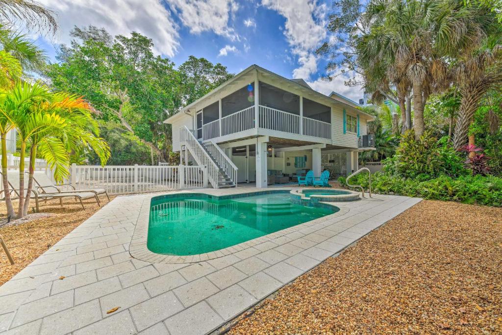 a house with a swimming pool in front of a house at Canalfront Anna Maria Cottage with Pool and Hot Tub! in Anna Maria