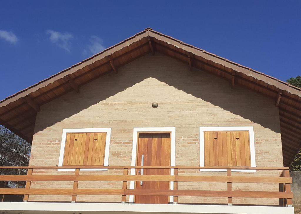 a house with two doors and a wooden fence at Chalé refúgio in Monte Verde