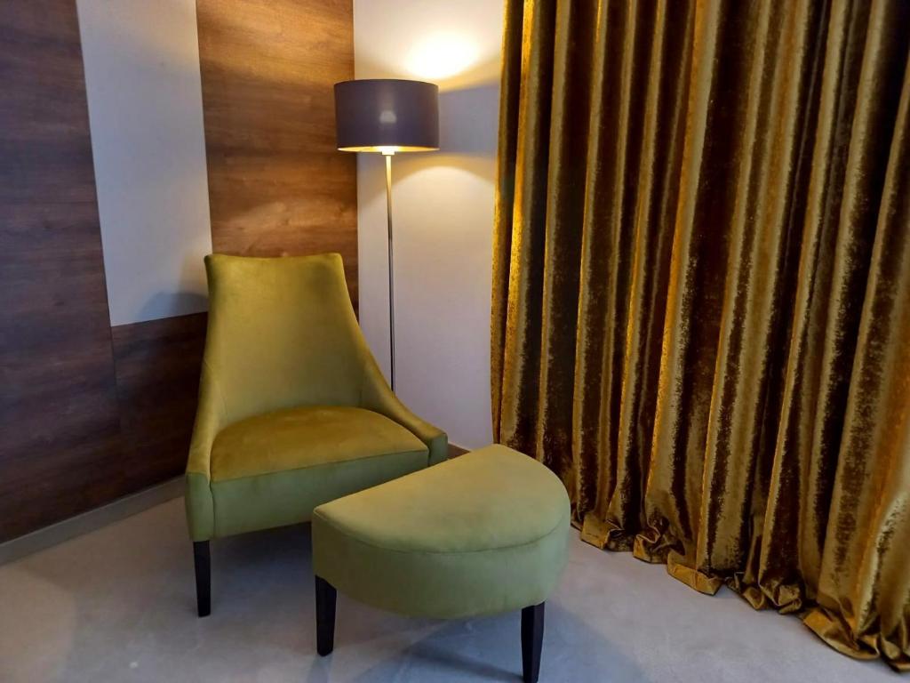 a yellow chair and a stool in a room at Hotel Meduza in Senj