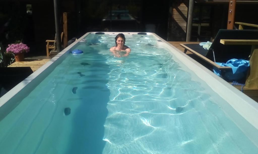 a woman in a swimming pool with a bottle at coucher de soleil vensac ocean Montalivet in Vensac