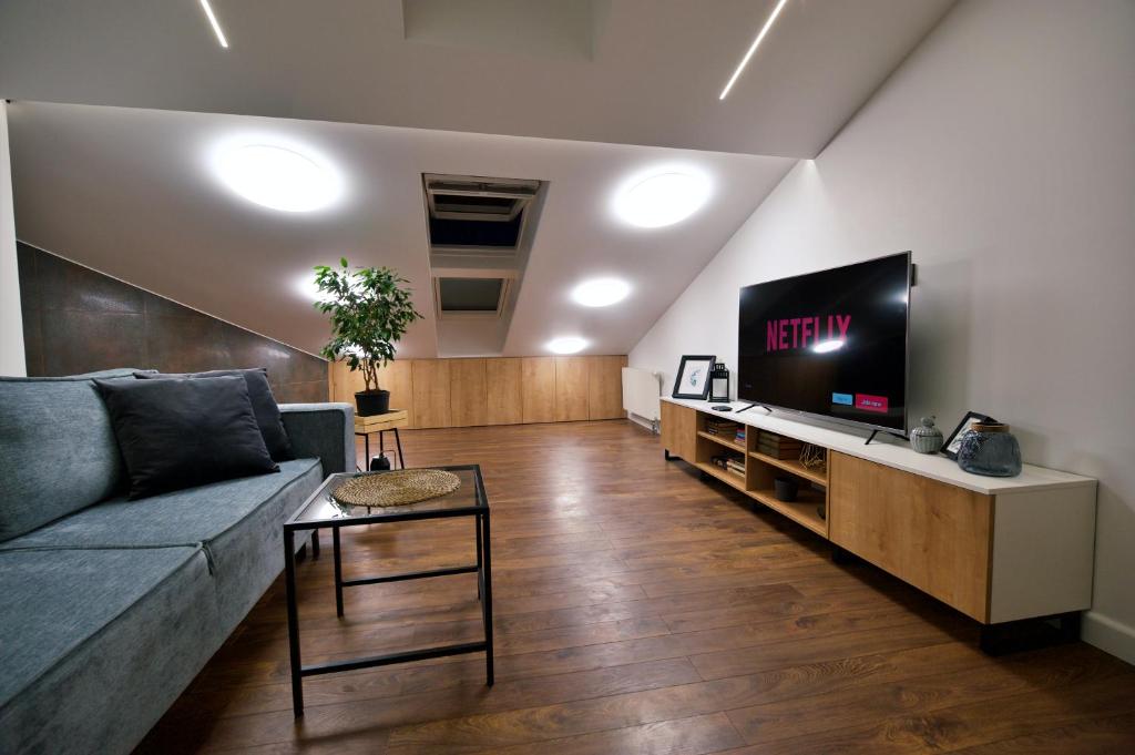 uma sala de estar com um sofá e uma televisão de ecrã plano em Last floor two level apartment with fantastic view em Riga