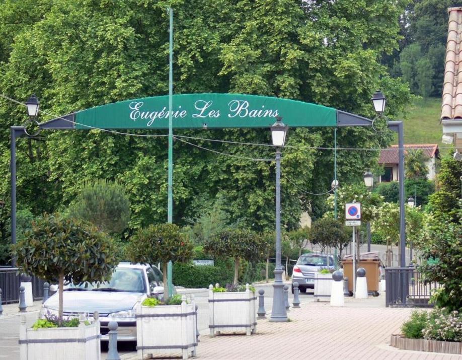 le Refuge d'Eugénie في Bahus-Soubiran: موقف للسيارات مع مظلة خضراء وسيارات