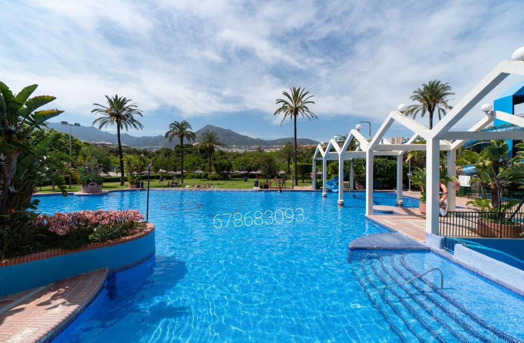 basen w ośrodku z palmami w obiekcie Benalbeach w mieście Benalmádena