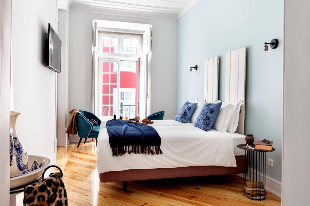 1 dormitorio con 1 cama grande con almohadas azules en LeL Madalena GuestHouse en Lisboa