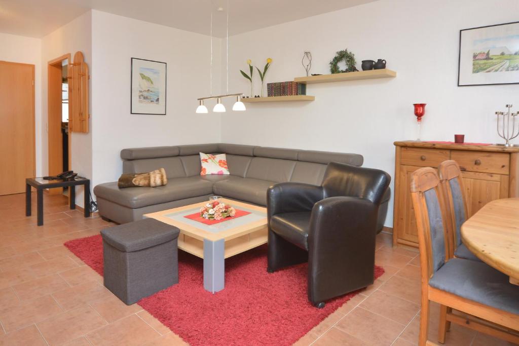 een woonkamer met een bank en een tafel en stoelen bij Ferienpark Freesenbruch Reihenhaus 5b - Seehund in Zingst