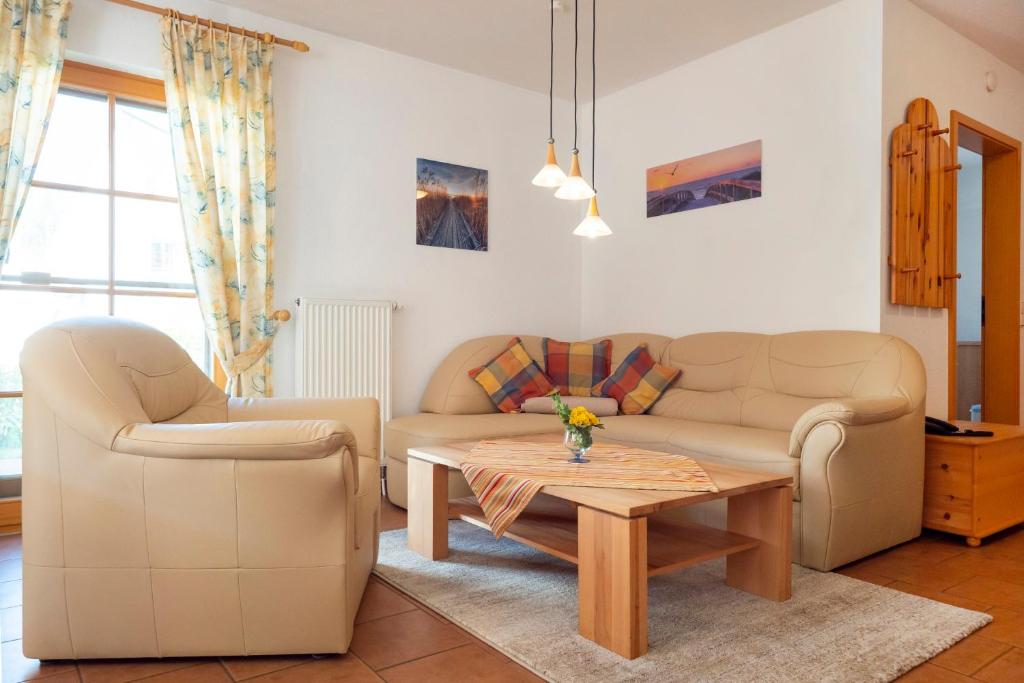 Una sala de estar con dos sofás y una mesa de café. en Ferienpark Freesenbruch Reihenhaus 6b - Schwalbe, en Zingst