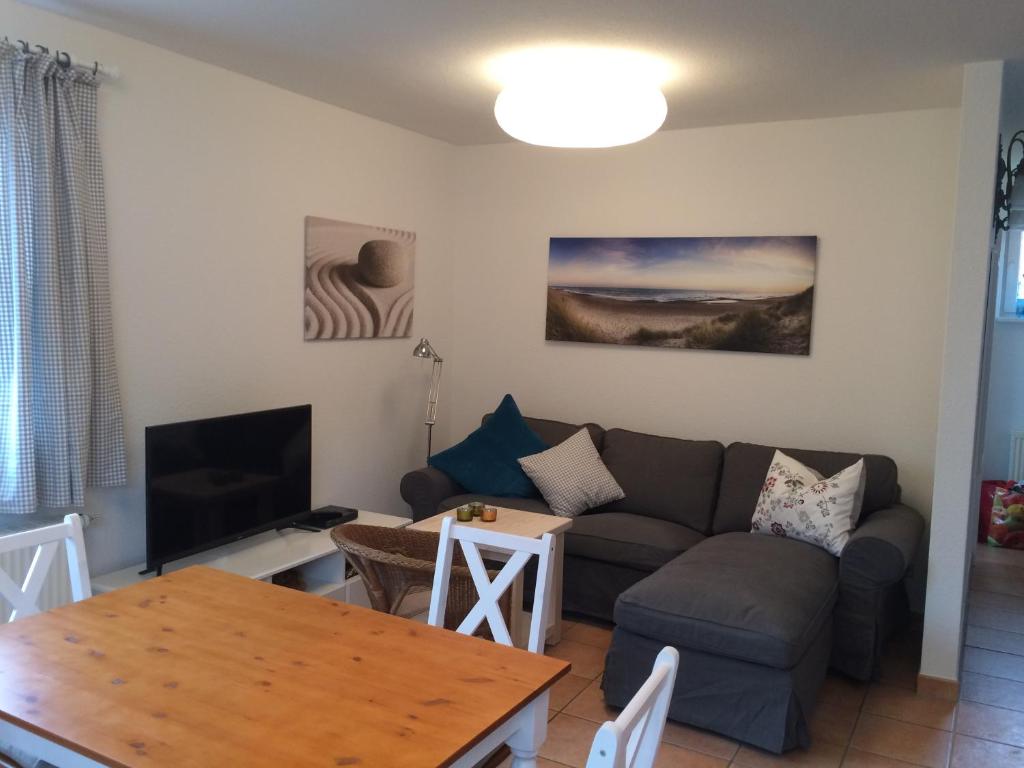 a living room with a couch and a table at Haus Zeesenboot Luv in Hiddensee