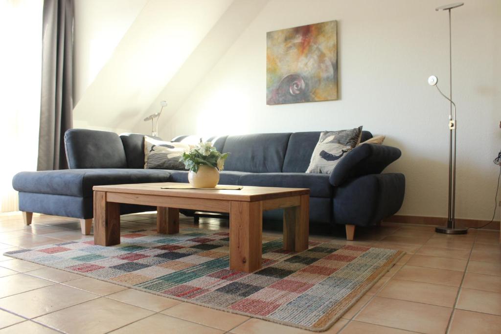 a living room with a blue couch and a coffee table at Residenz am Strand Wohnung 2-40 in Zingst